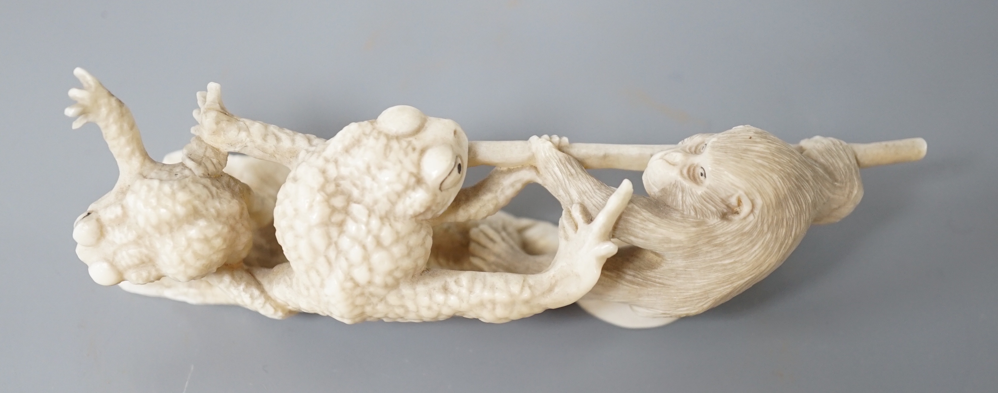 A Japanese ivory okimono of a monkey and toads, Meiji period, 12cm
